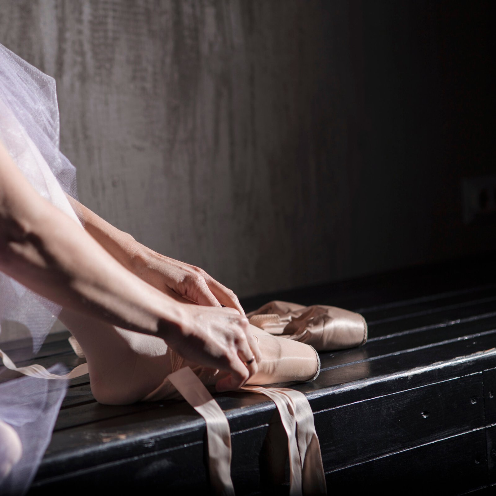 crop-ballet-dancer-putting-pointe-shoes